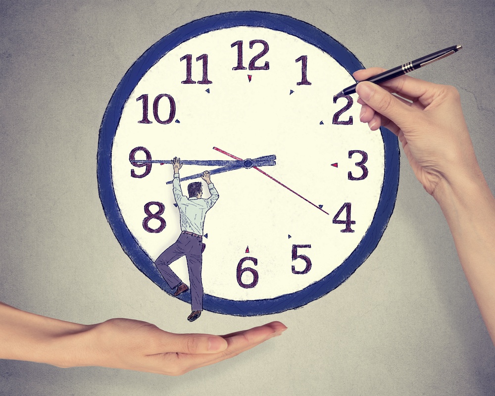 Business man trying to stop time. Man hanging on clock arrow isolated on gray office wall background. Time pressure passing past concept